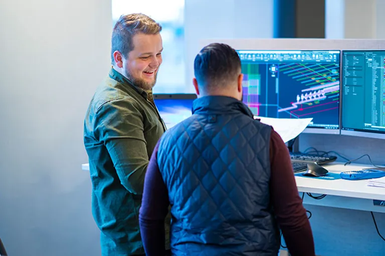 Två av Bravidas projektledare vid datorskärmar