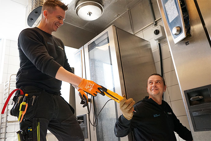 Två tekniker utför service i storkök