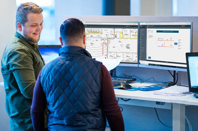 två personer i ett samtal vid datorskärmar