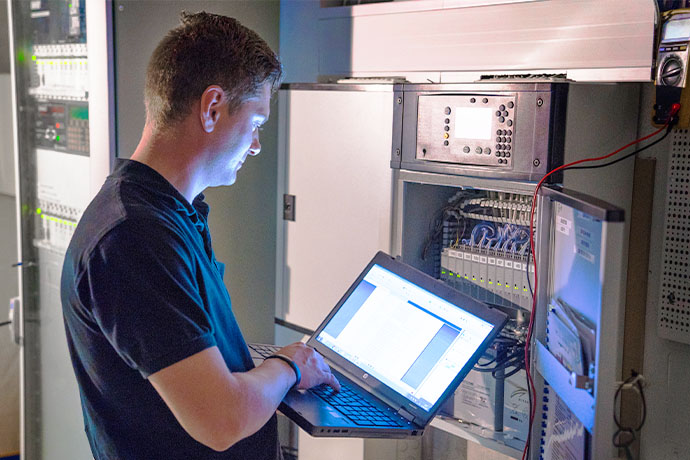 Bilden visar en person med en dator i en serverhall