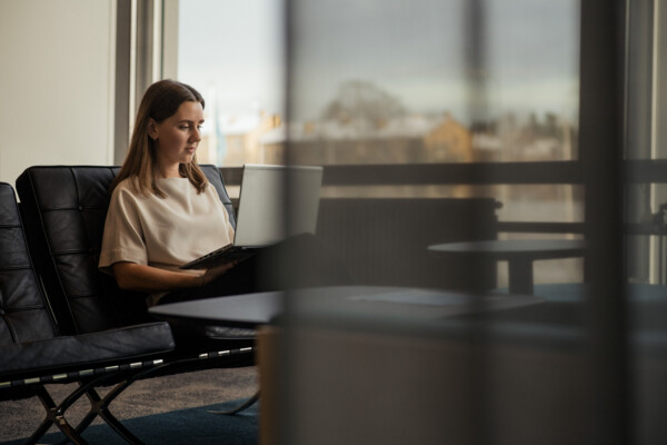 En person vid en dator i kontorsmiljö/A person by a computer in an office environment