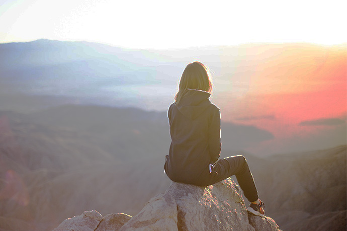 En kvinna som sitter på en klippa