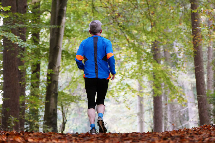 En man under en löptur i skogen