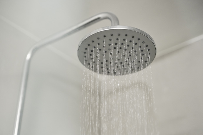 Bilden visar en takdusch med rinnande vatten i ett badrum