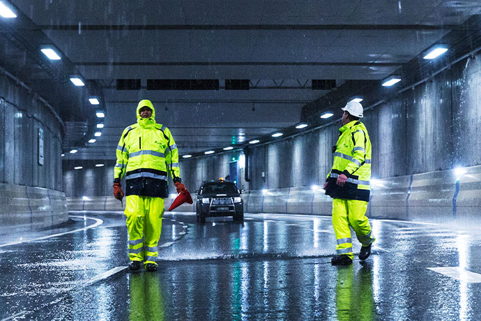 Två tekniker i en tunnel med sprinklersystem i taket