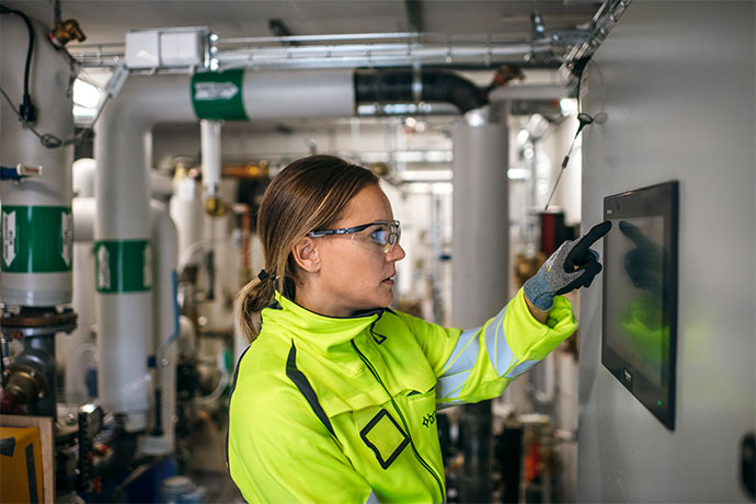 Medarbetare som övervakar och styr tekniska system i en industrianläggning.