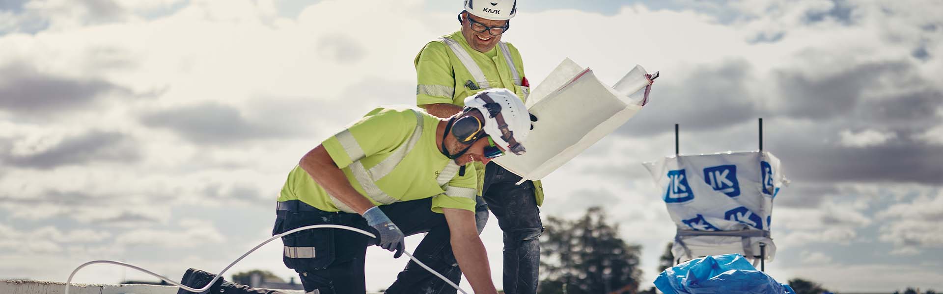 Bilden visar två tekniker under en installation på ett bygge