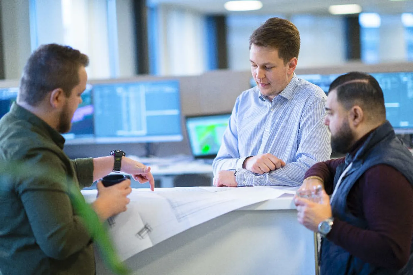 Tre medarbetare diskuterar en ritning