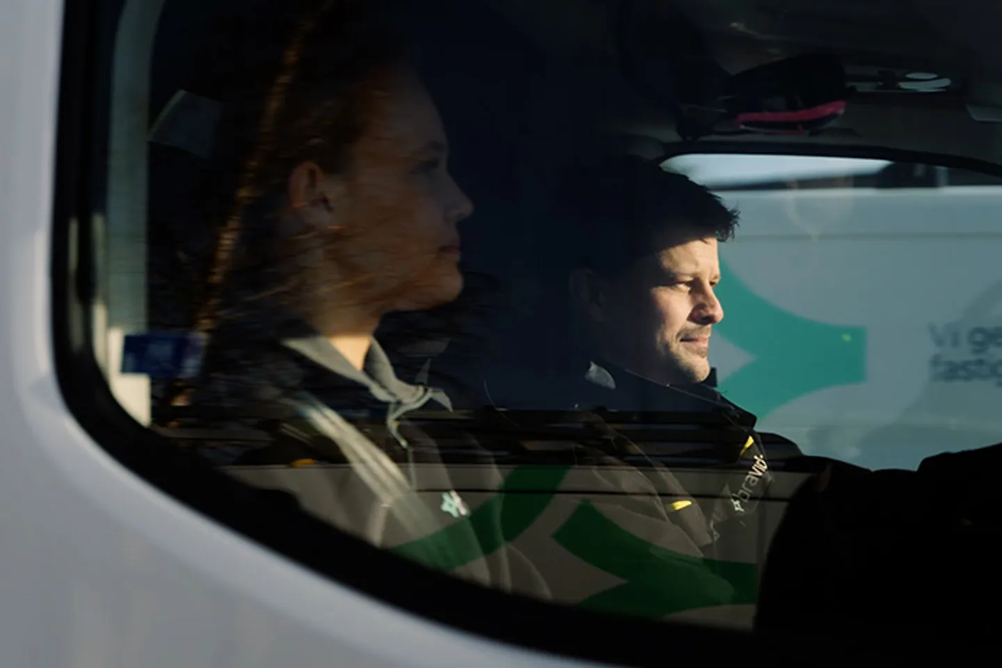 Bilden visar två servicetekniker i en servicebil