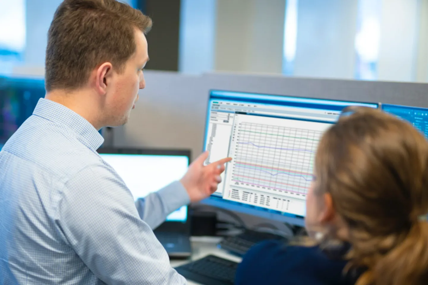 Två personer i diskussion vid en dator