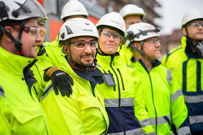 Bilden visar medarbetare i grupp med varselkläder och hjälmar på