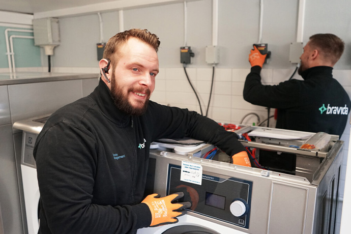 Två montörer gör en installation av tvättmaskiner