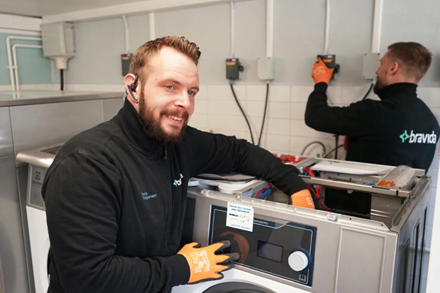 Två montörer gör en installation av tvättmaskiner